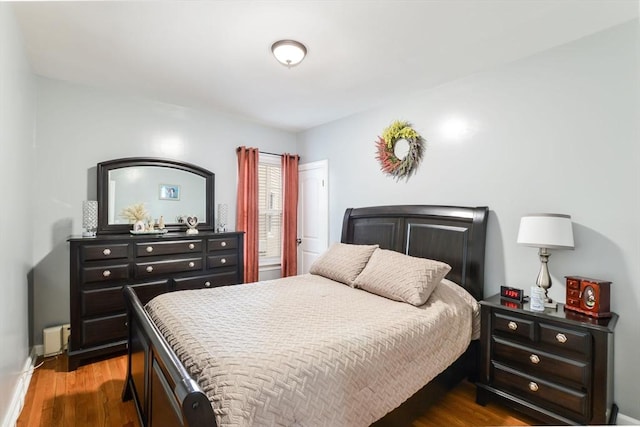 bedroom with dark wood-style flooring