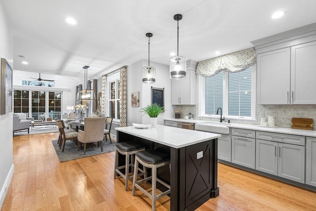 kitchen with decorative light fixtures, sink, decorative backsplash, and a kitchen island