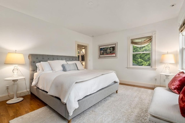 bedroom featuring wood finished floors and baseboards