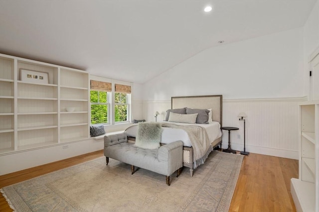 bedroom with a wainscoted wall, wood finished floors, vaulted ceiling, and recessed lighting