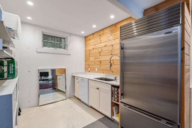 kitchen with stainless steel built in fridge, dishwasher, a sink, white cabinets, and recessed lighting