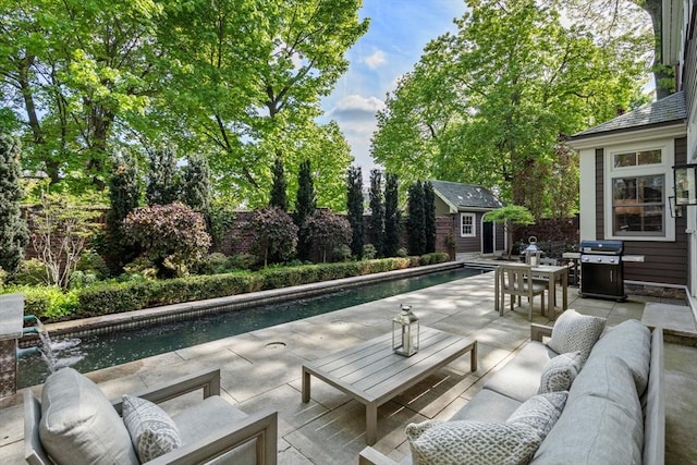 view of patio / terrace featuring an outdoor living space, an outdoor structure, grilling area, an outdoor pool, and a fenced backyard