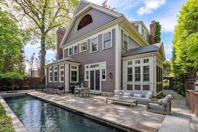 back of house with a patio area, a chimney, fence, and an outdoor hangout area