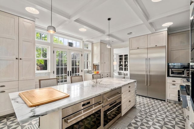 kitchen with appliances with stainless steel finishes, tile patterned floors, coffered ceiling, beam ceiling, and light stone counters