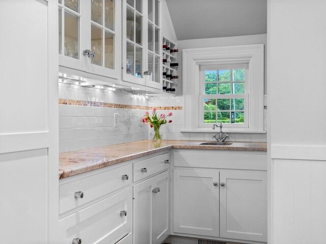 bar with a sink and tasteful backsplash