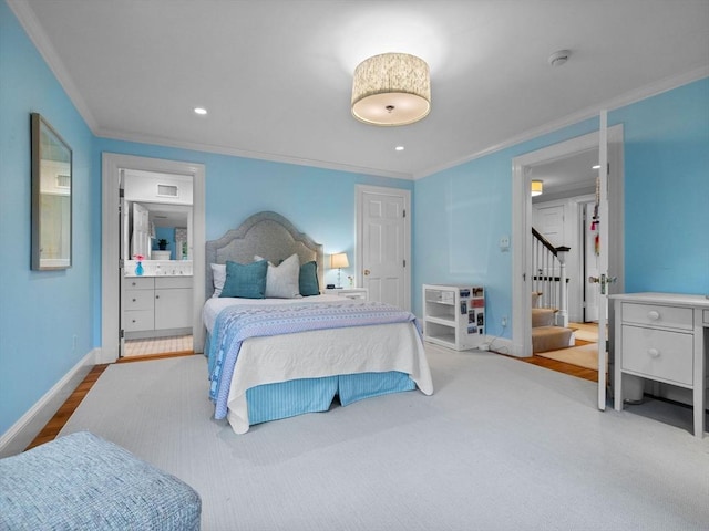 bedroom with ornamental molding, baseboards, recessed lighting, ensuite bathroom, and wood finished floors