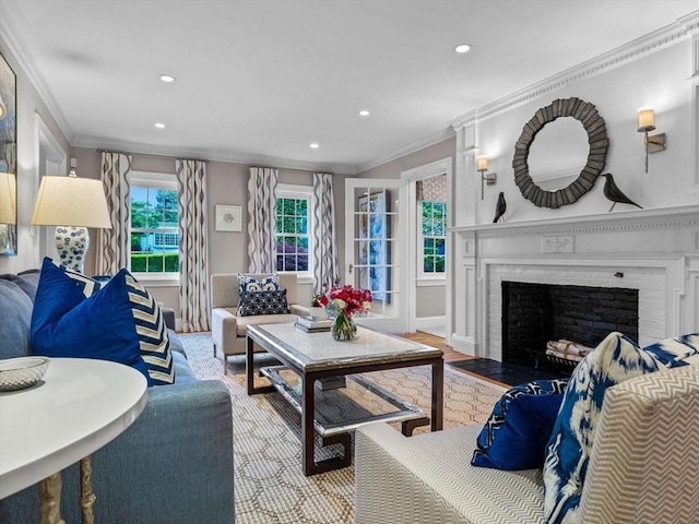 living room featuring ornamental molding, recessed lighting, a brick fireplace, baseboards, and wood finished floors