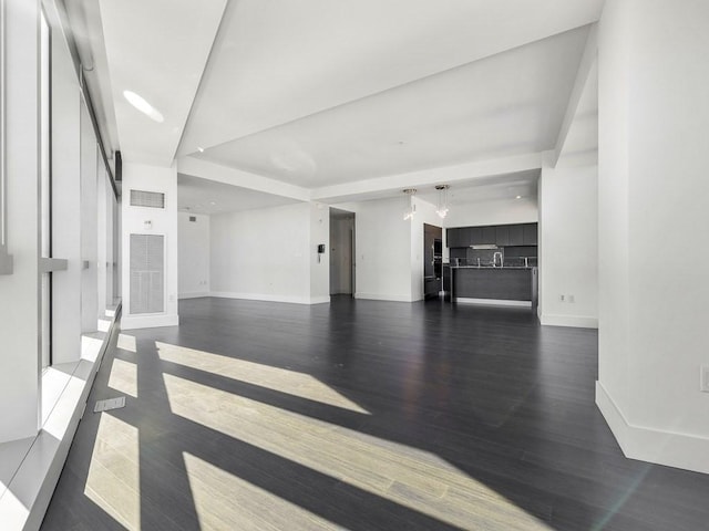 unfurnished living room with dark wood-type flooring