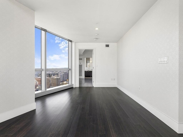 unfurnished room featuring expansive windows and dark hardwood / wood-style floors