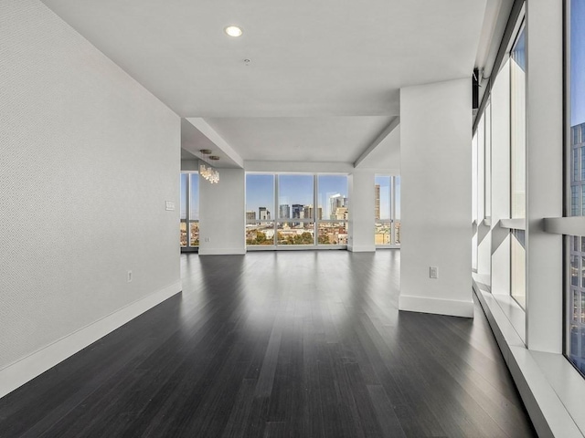 unfurnished room featuring dark hardwood / wood-style flooring and a wall of windows