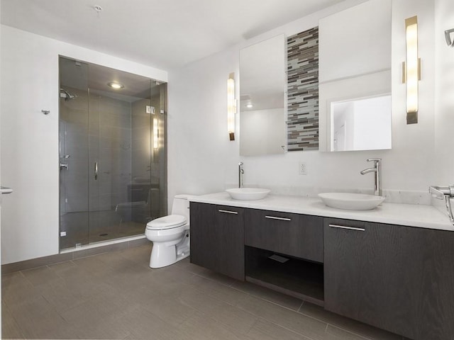 bathroom featuring vanity, an enclosed shower, and toilet