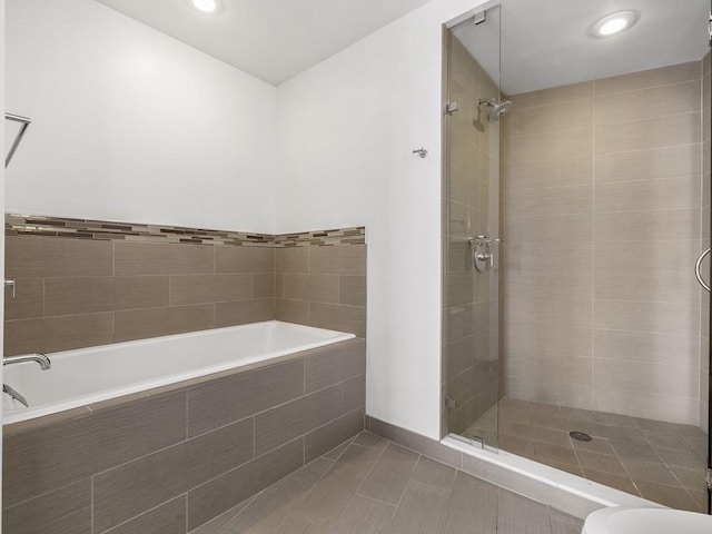 bathroom with tile patterned flooring, a tile shower, and toilet