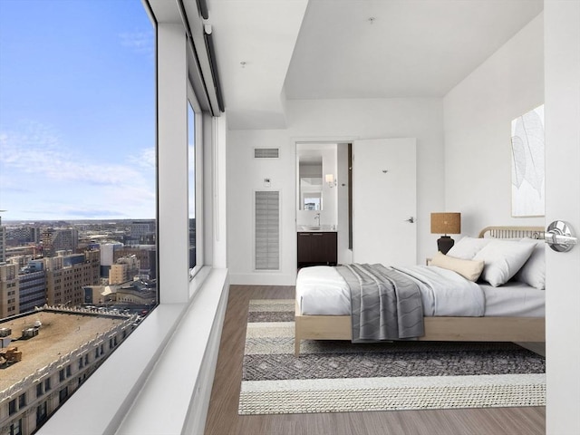 bedroom featuring a wall of windows and dark hardwood / wood-style flooring