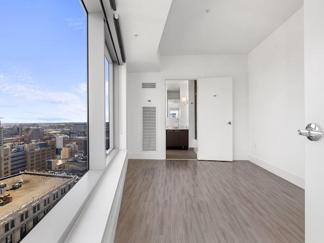 empty room featuring dark hardwood / wood-style flooring and a wall of windows