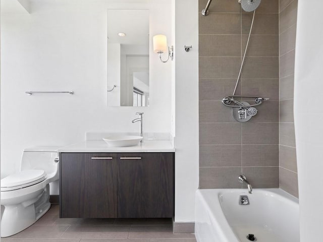 full bathroom featuring tiled shower / bath, vanity, and toilet