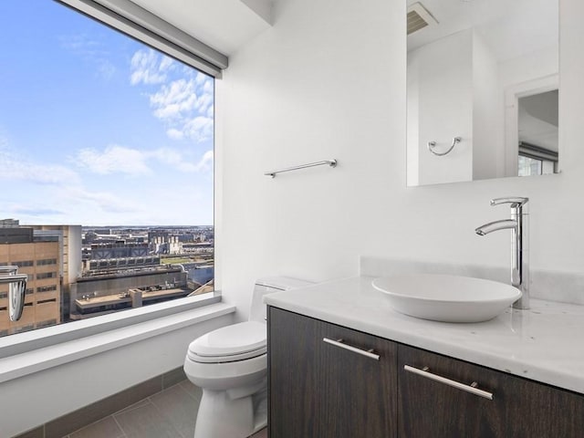 bathroom featuring vanity, tile patterned floors, and toilet