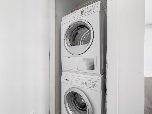 washroom featuring stacked washer and clothes dryer