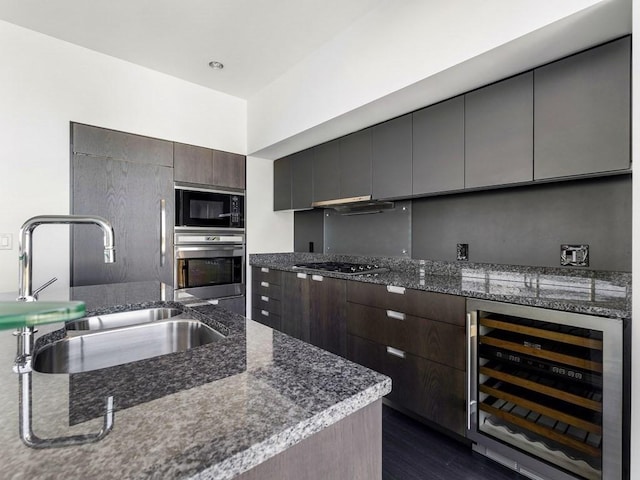 kitchen featuring dark wood-type flooring, sink, dark brown cabinets, stainless steel appliances, and beverage cooler