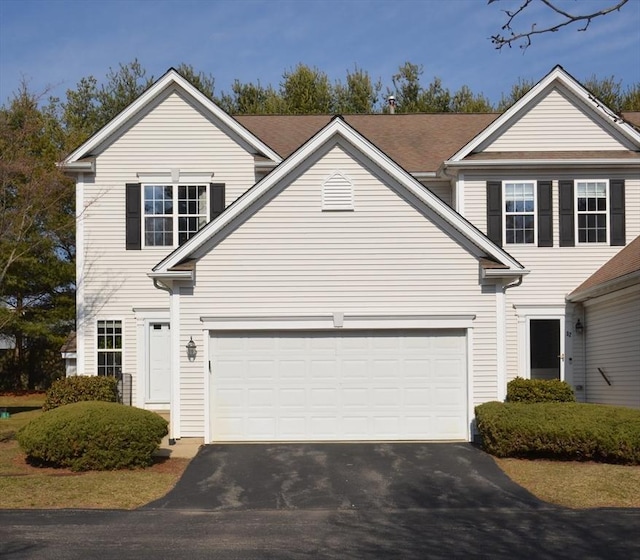 traditional-style home featuring driveway and an attached garage