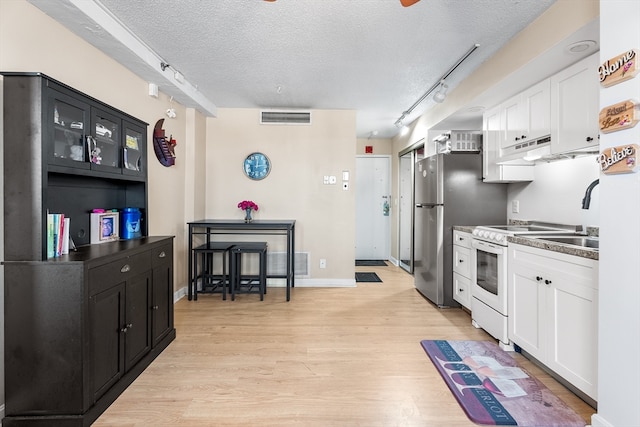 kitchen featuring track lighting, white range oven, a textured ceiling, and light hardwood / wood-style flooring