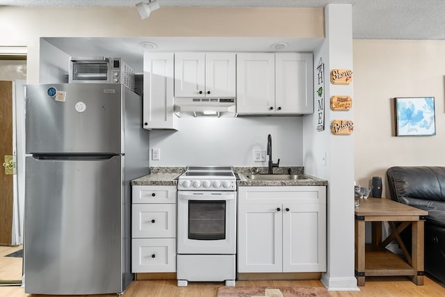 kitchen featuring white range, sink, stainless steel fridge, light hardwood / wood-style floors, and white cabinetry