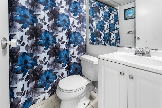 bathroom with toilet, vanity, and tile patterned floors