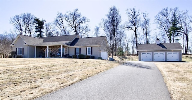 ranch-style home with stone siding, a chimney, a garage, and a front yard