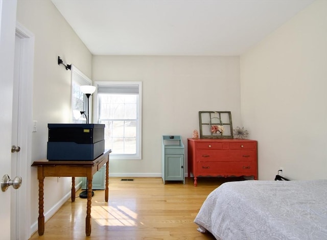 bedroom featuring visible vents, baseboards, and light wood-style floors