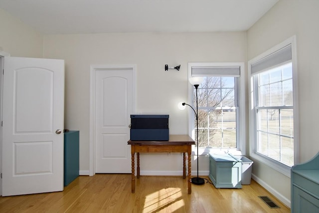 interior space with light wood-style flooring, plenty of natural light, and visible vents