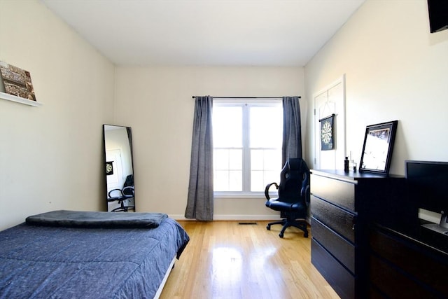 bedroom with light wood-style flooring and baseboards