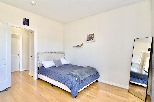 bedroom with baseboards and light wood finished floors