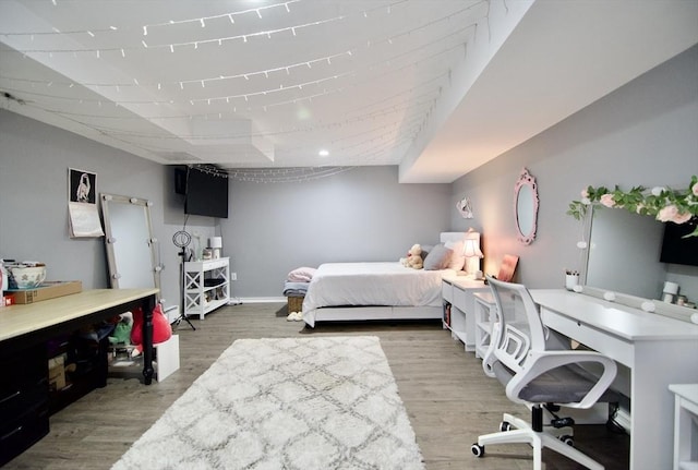 bedroom with wood finished floors and baseboards