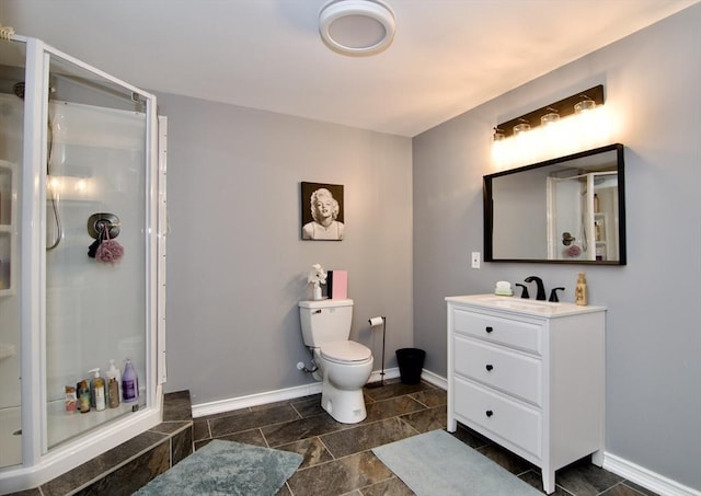 full bath with a shower stall, toilet, vanity, and baseboards