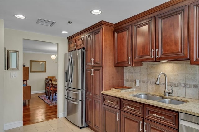 75-83 Cambridge Pkwy Unit W403, Cambridge, MA 02142 - kitchen with stainless steel appliances, a sink, baseboards, light stone countertops, and decorative backsplash