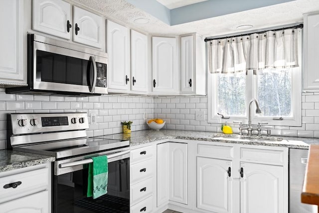 kitchen featuring tasteful backsplash, stainless steel appliances, sink, and white cabinets