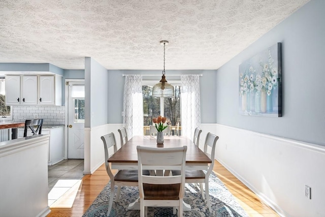 dining room featuring light hardwood / wood-style flooring and a textured ceiling