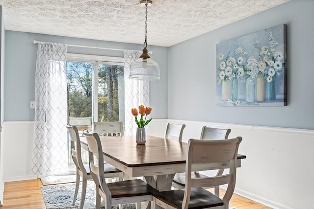 dining area featuring hardwood / wood-style flooring and a textured ceiling