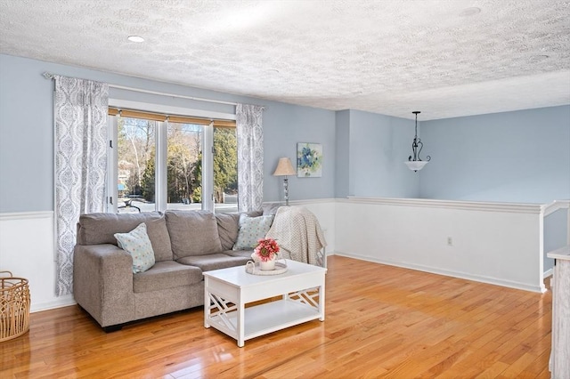 living room featuring light hardwood / wood-style flooring and a textured ceiling