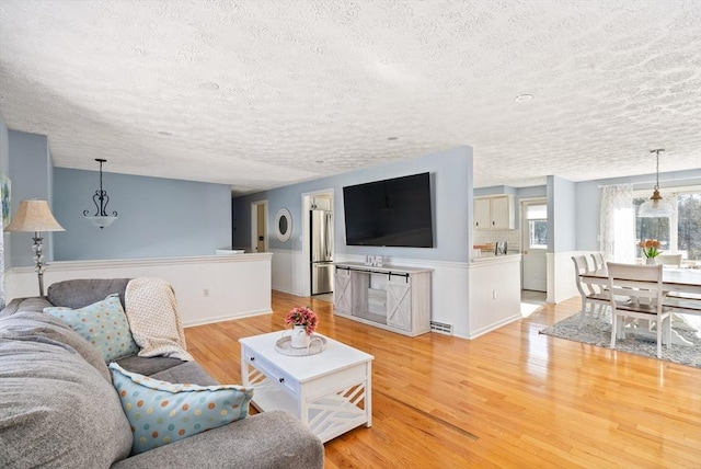 living room with light hardwood / wood-style flooring and a textured ceiling