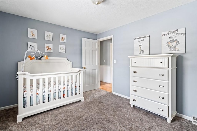 carpeted bedroom with a nursery area and a textured ceiling