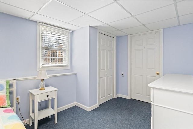 carpeted bedroom with a paneled ceiling and a closet