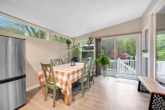 sunroom featuring plenty of natural light, wood finished floors, lofted ceiling, and baseboards