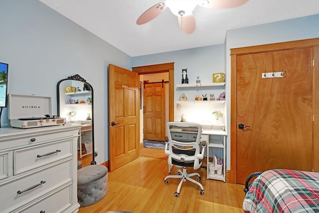 bedroom with light wood-style floors and a ceiling fan