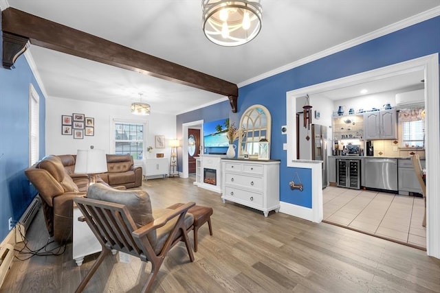 living area featuring a chandelier, light wood finished floors, beverage cooler, baseboards, and an AC wall unit