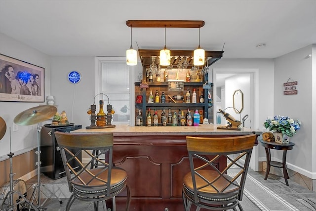 indoor bar with baseboards and decorative light fixtures