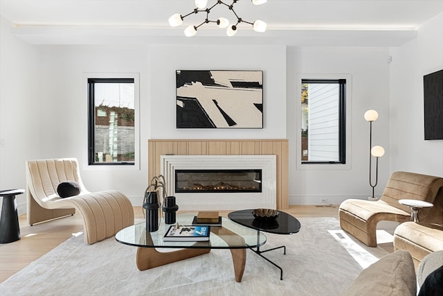 living room with light wood-type flooring, a notable chandelier, and plenty of natural light