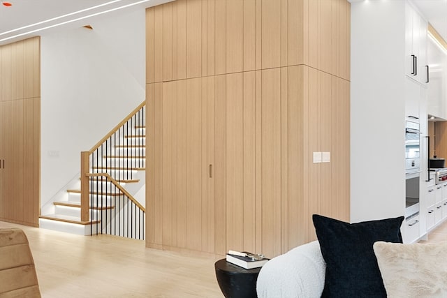 interior space with light hardwood / wood-style floors and wooden walls