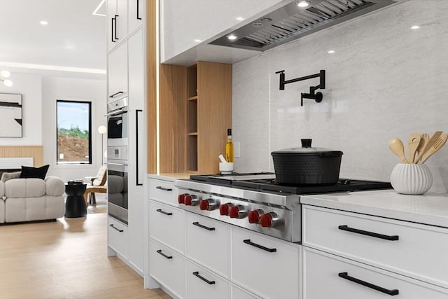 936 Central Ave, Needham, MA 02492 - kitchen featuring premium range hood, stainless steel gas cooktop, white cabinetry, light countertops, and light wood-type flooring