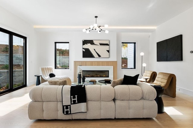 936 Central Ave, Needham, MA 02492 - living room with a chandelier, wood finished floors, a glass covered fireplace, and baseboards