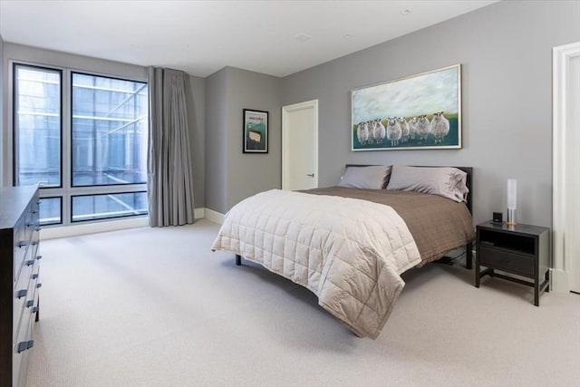 bedroom featuring baseboards and light carpet